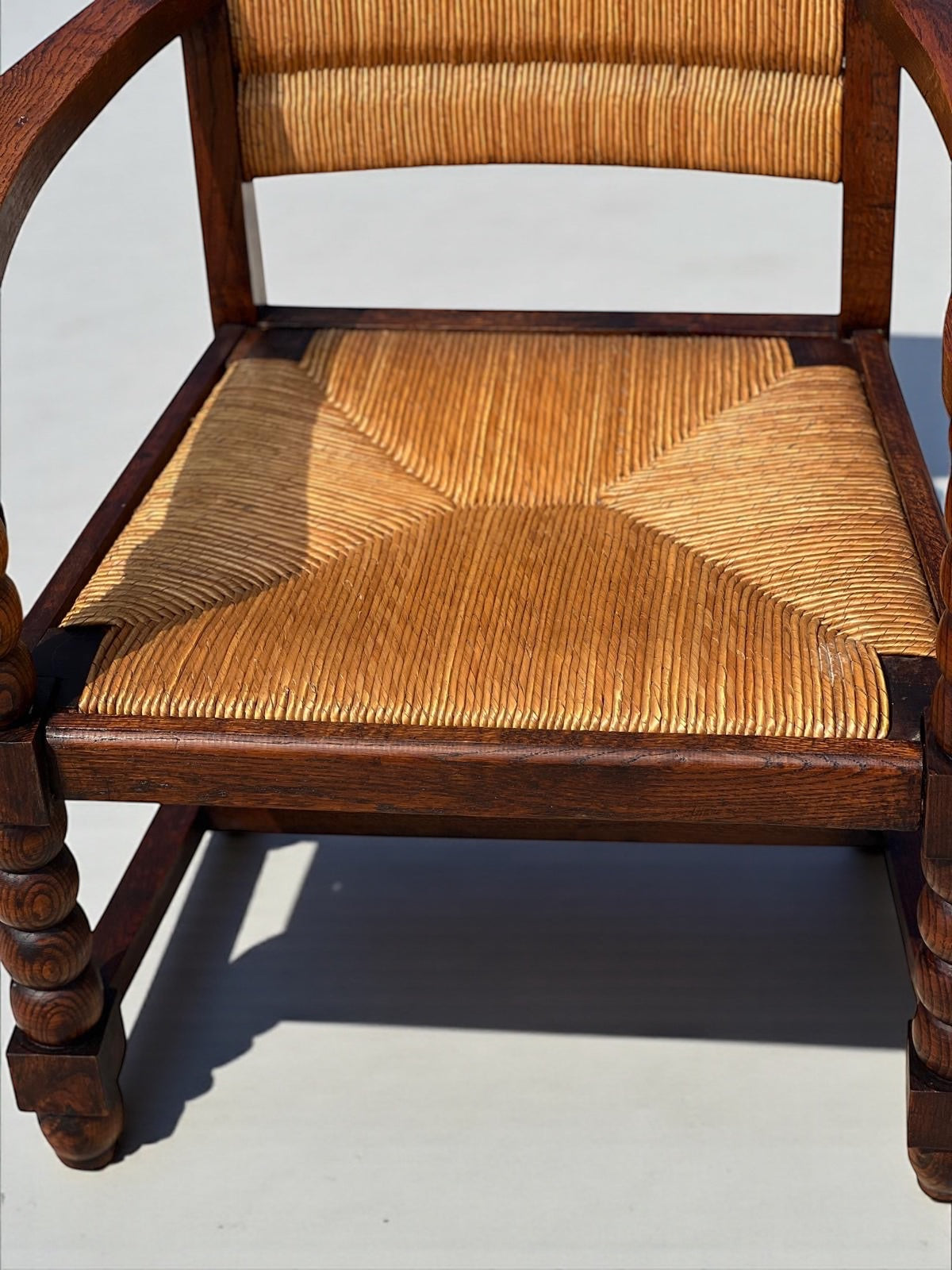 Fauteuil en chêne teinté et paille, travail français 1950