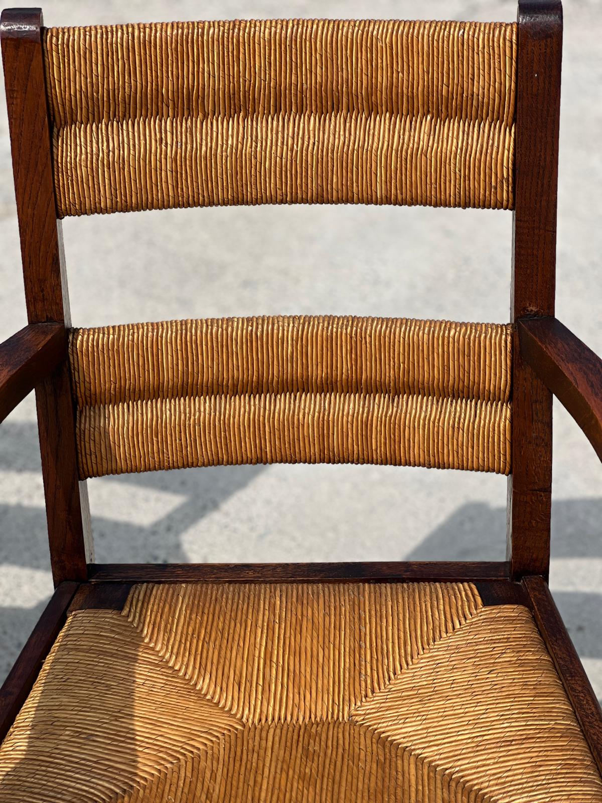 Fauteuil en chêne teinté et paille, travail français 1950