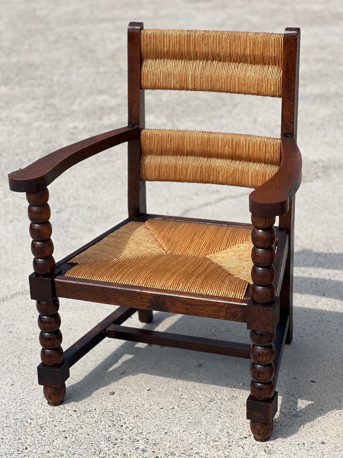 Fauteuil en chêne teinté et paille, travail français 1950
